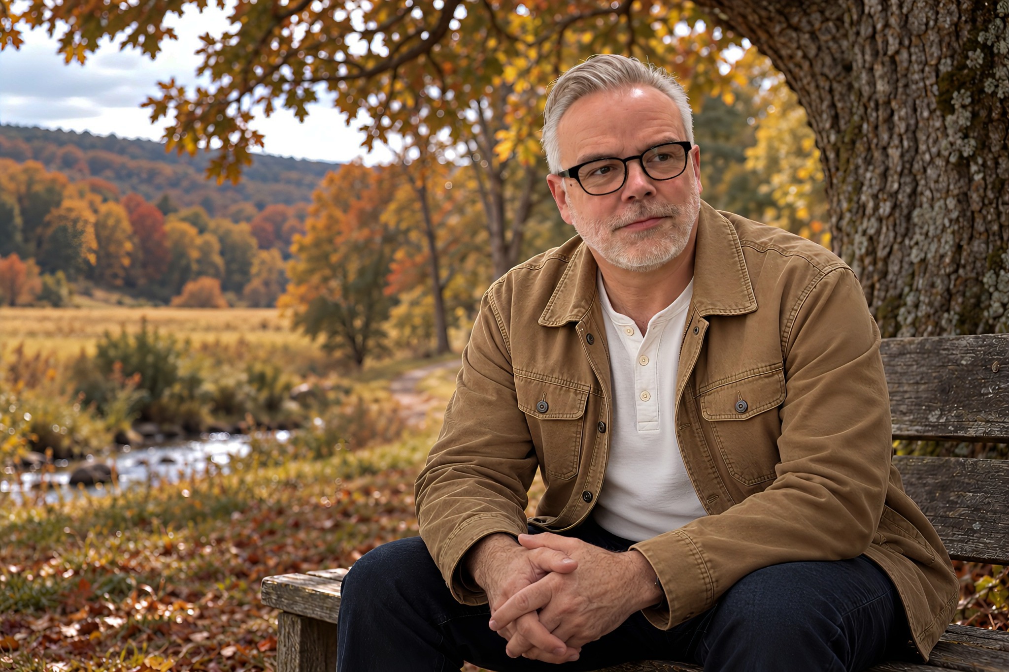 Darrell Bryant seated beneath an oak tree overlooking autumn fields and a creek in the Pennsylvania countryside